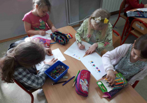 Dzieci malują kredkami na kartonach, w jaki sposób należy dbać o środowisko